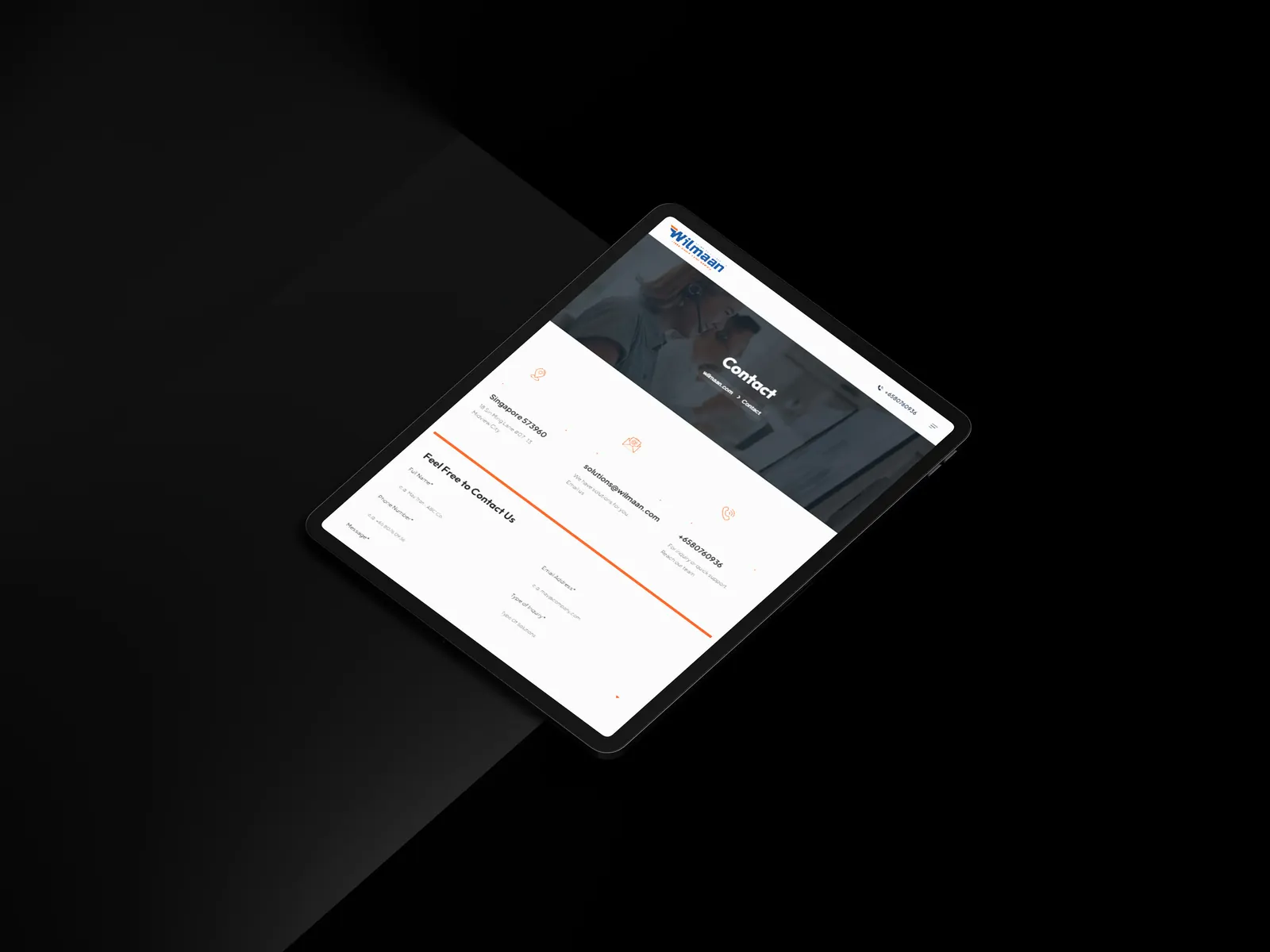 Phone standing on a dark textured surface showing Wilmaan branding text