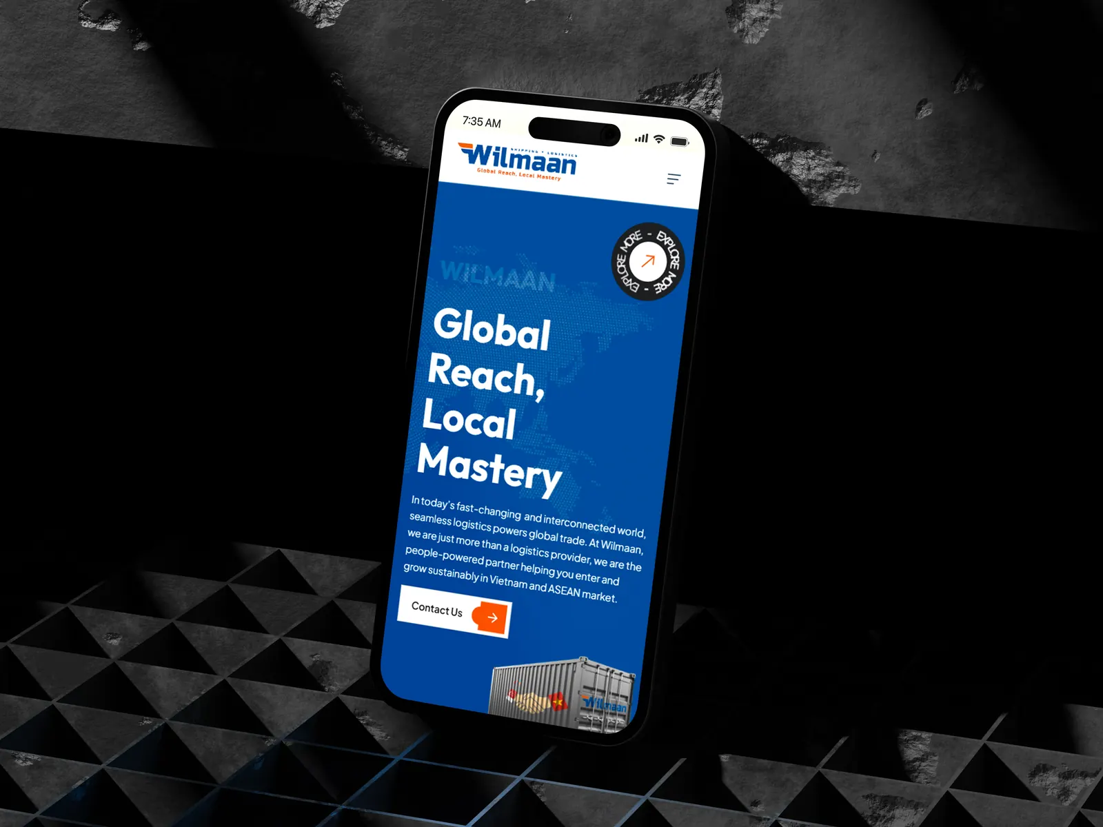 Phone standing on a dark textured surface showing Wilmaan branding text